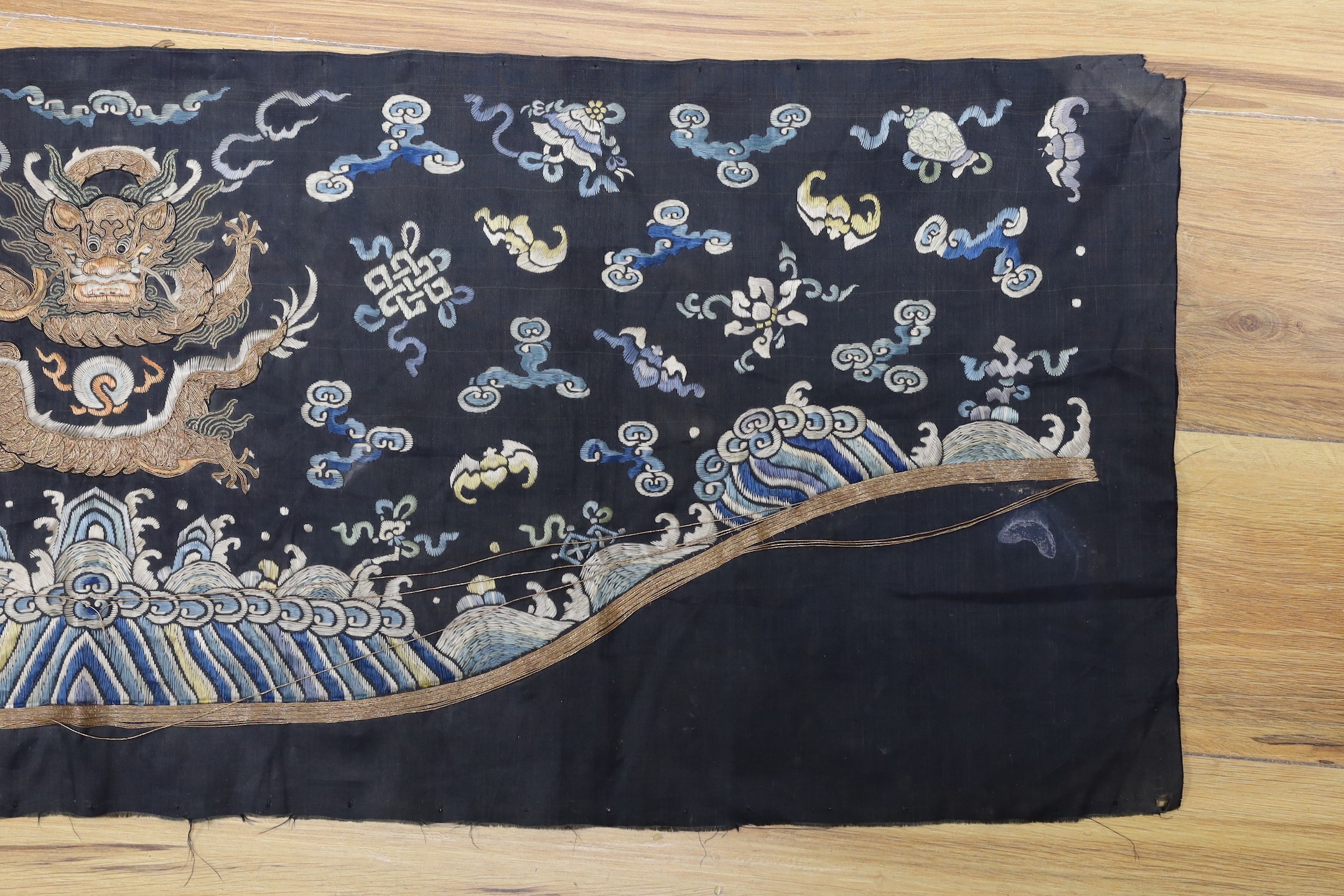 A Chinese late 19th century embroidery of a dragon, probably from a Chinese robe or hanging 37x105cm